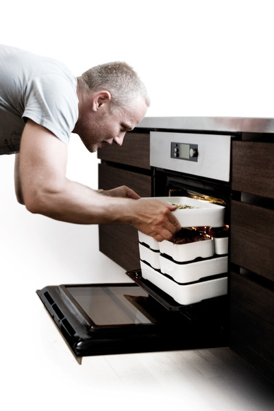 Man_putting_stackable_oven-to-table_cookware_by_christian_bjorn_into_oven-sixhundred